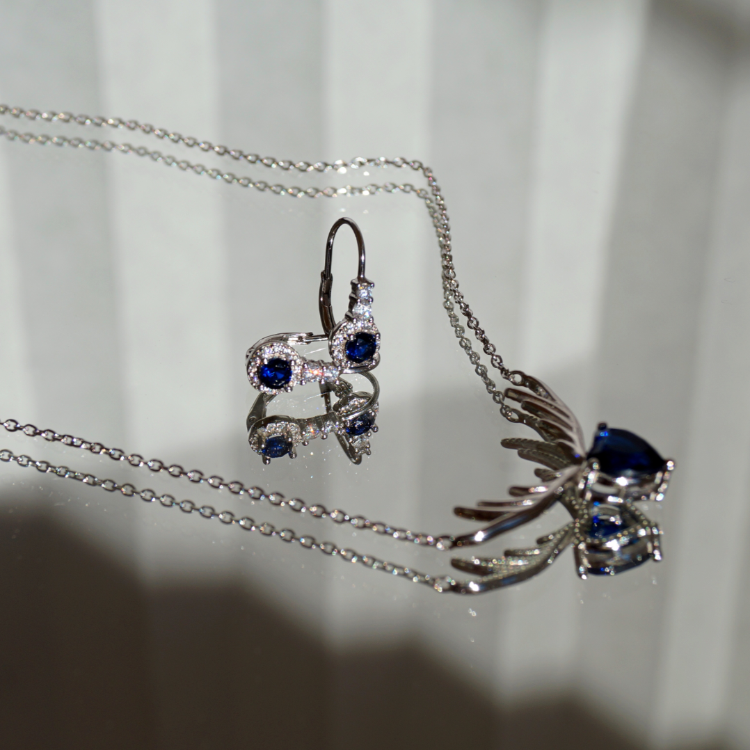 Srebrne 925 nausnice, alkice. Krase ih prozirni cirkoni koji okružuju jedan tamno plavi, sjajni cirkon