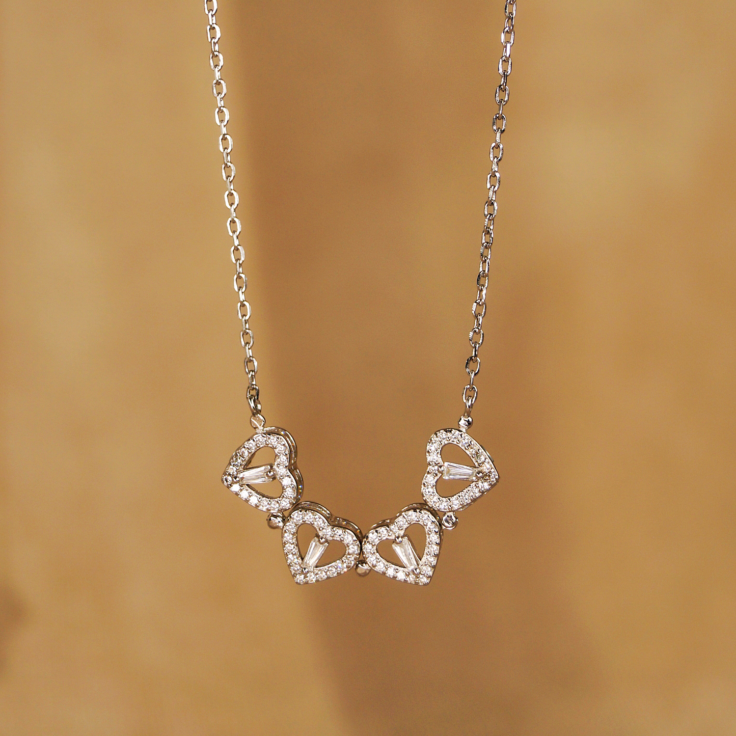 Lančić od srebra 925, visoki sjaj - sa prozirnim cirkonima. Lančić se može nositi na 2 načina, privjesak može biti u obliku djeteline ili kada se magnet odvoji, nastane niz od 4 srca