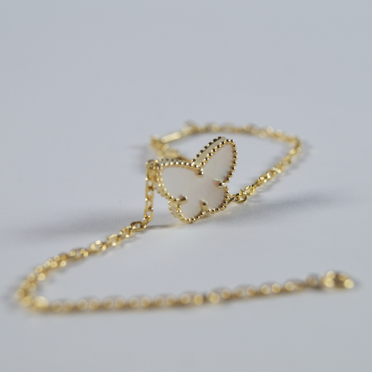 Pozlaćena narukvica s leptir privjeskom od sedefa koji se prelijeva u duginim bojama. Pažljivo izabran srebrni nakit 925.