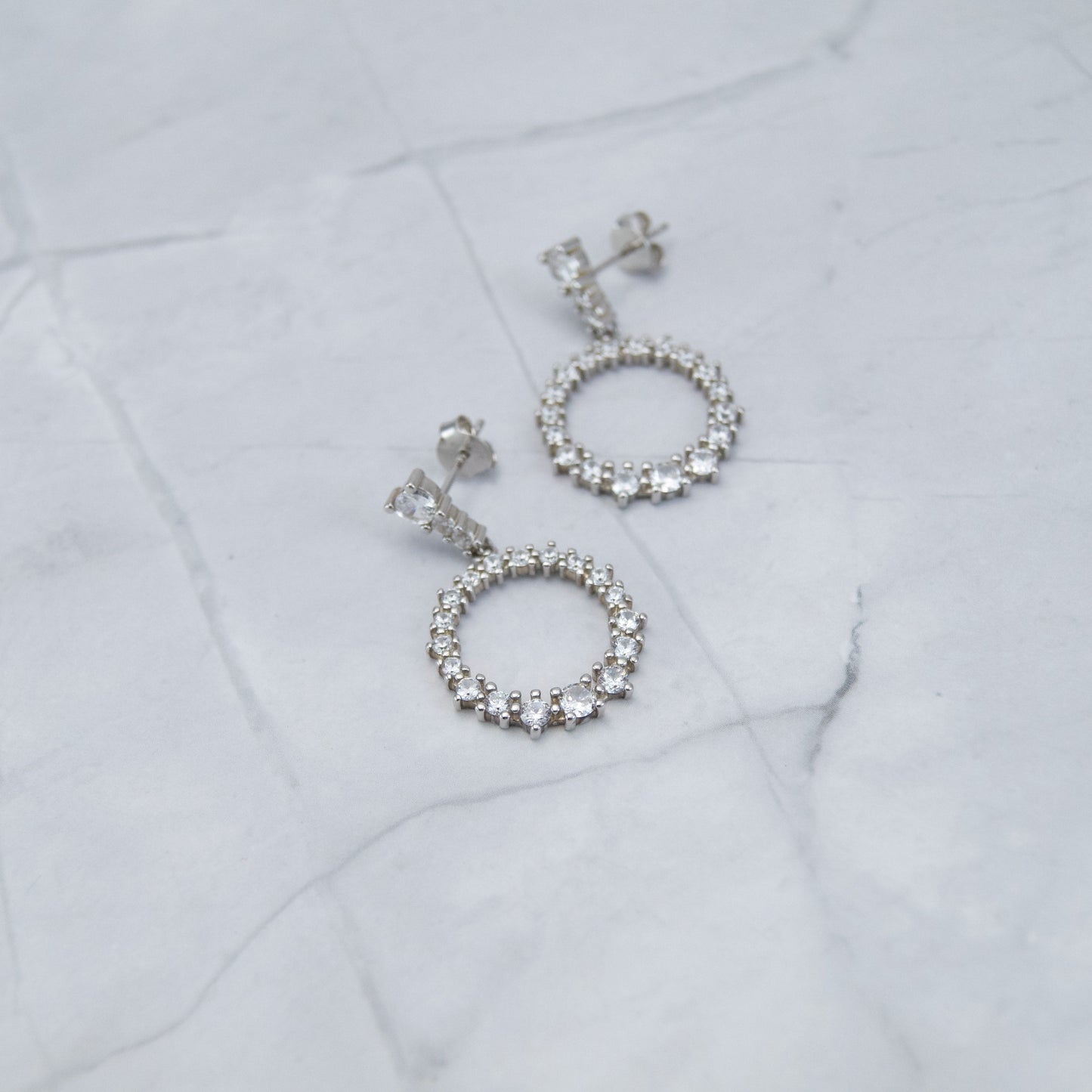 Srebrne 925 naušnice. Prozirni cirkoni su nanizani u krug i sjaje poput najsjajnije zvijezde. Naušnice su viseće