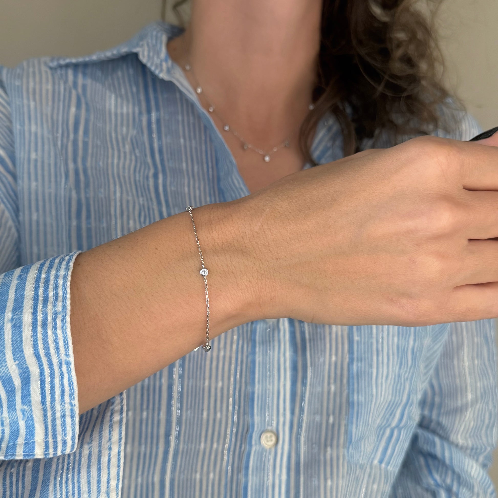 Ela srebrna narukvica s privjescima od prozirnih cirkona na ruci