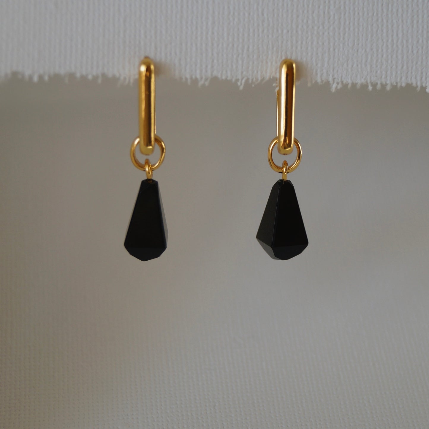 Opsidijan nastaje naglim hlađenjem lave i time stvara prekrasan stakleni kamen duboke, tamne boje. Za opsidijan se vjeruje da cisti negativnu energiju zbog čega ga se obično nosi uz tijelo. Obsidian naušnice izrađene od srebra sa 18K pozlatom su idealne za tu svrhu jer ih krasi prekrasan privjesak izrađen od crnog opsidijana. 