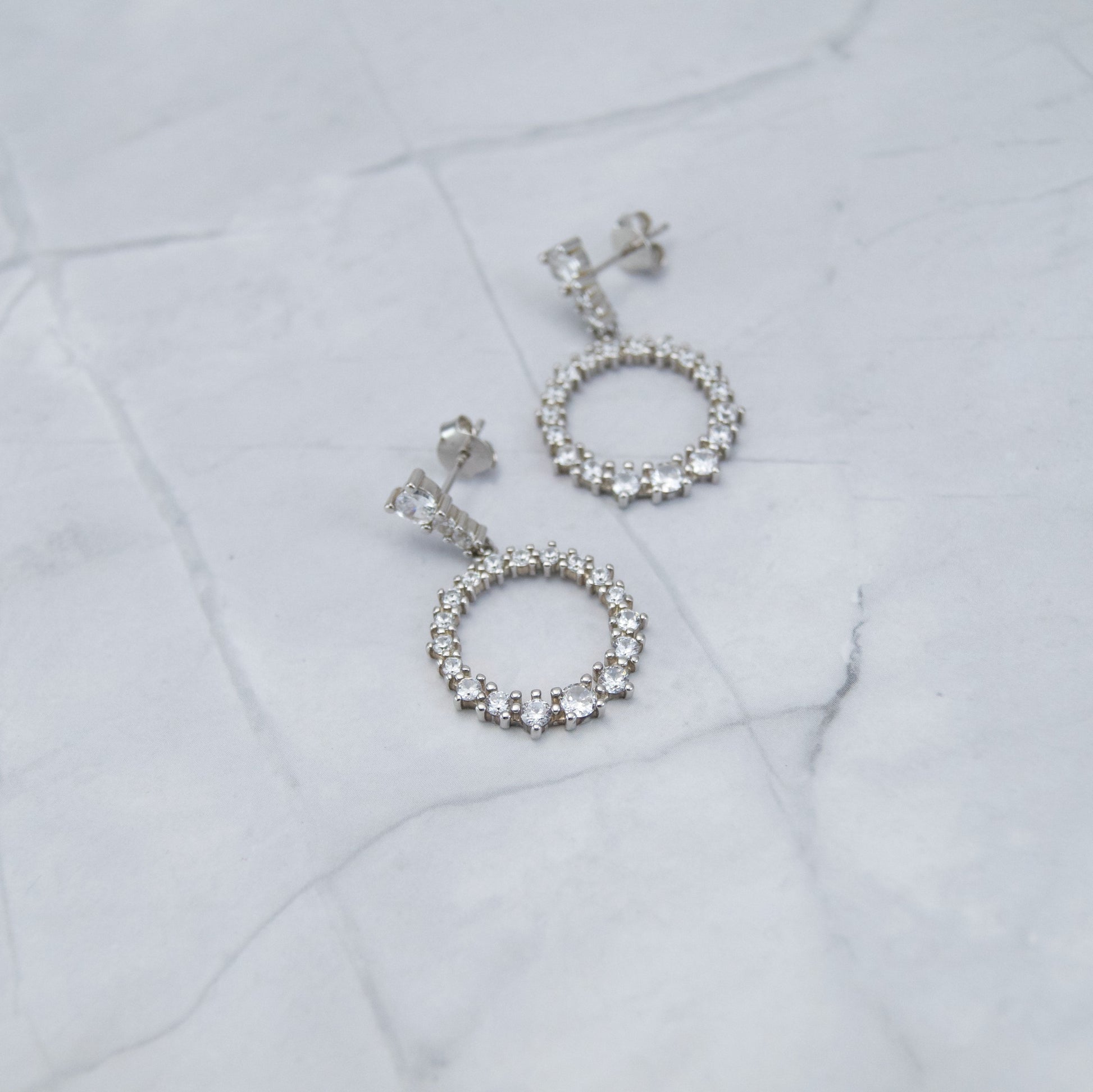 Srebrne 925 naušnice. Prozirni cirkoni su nanizani u krug i sjaje poput najsjajnije zvijezde. Naušnice su viseće